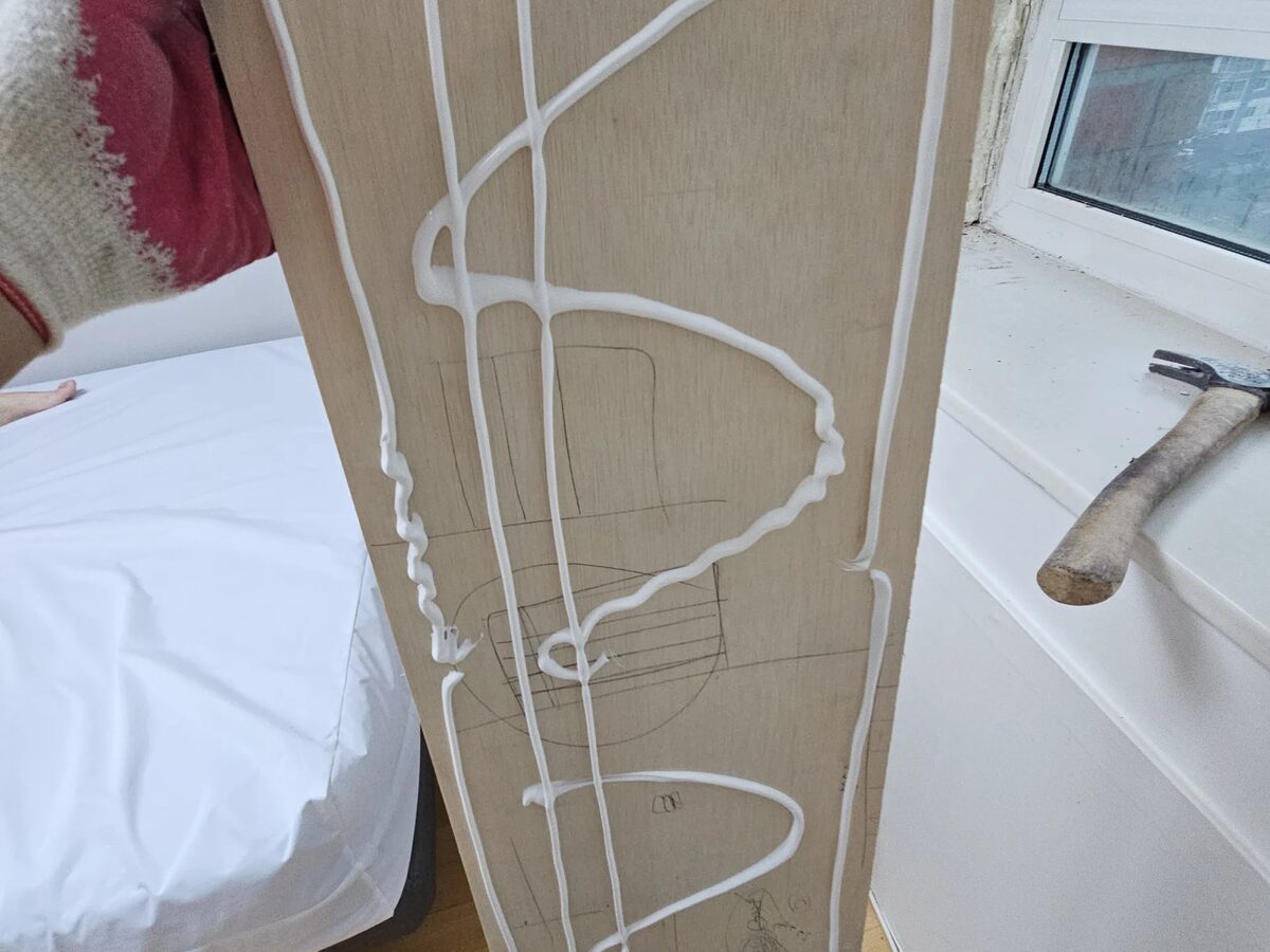 손상된 벽면에 재단한 합판을 고정하는 모습